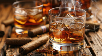 Arrangement von Zigarren und Whisky-Gläsern